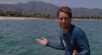 Movie still from “Forgetting Sarah Marshall” (2008), directed by Nicholas Stoller – A man standing in the water with his hand outstretched; Medium shot, Over the shoulder angle