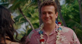 Movie still from “Forgetting Sarah Marshall” (2008), directed by Nicholas Stoller – A man wearing a pink shirt and a flower lei; Close Up shot, Over the shoulder angle