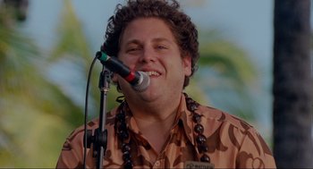 Movie still from “Forgetting Sarah Marshall” (2008), directed by Nicholas Stoller – A man with curly hair is singing into a microphone; Close Up shot, Low angle