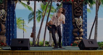 Movie still from “Forgetting Sarah Marshall” (2008), directed by Nicholas Stoller – A man standing on a stage holding a microphone; Wide shot, Over the shoulder angle