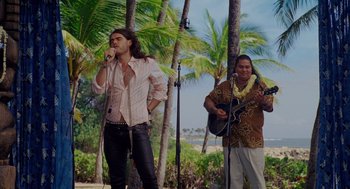 Movie still from “Forgetting Sarah Marshall” (2008), directed by Nicholas Stoller – A man singing into a microphone next to a man playing a guitar; Medium shot, Over the shoulder angle