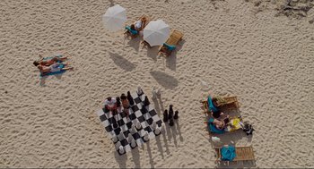 Movie still from “Forgetting Sarah Marshall” (2008), directed by Nicholas Stoller – An aerial view of people sitting on the beach; Extreme Wide shot, Overhead angle