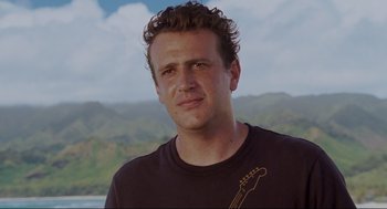 Movie still from “Forgetting Sarah Marshall” (2008), directed by Nicholas Stoller – A person wearing a t - shirt with mountains in the background; Close Up shot, Low angle