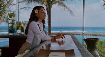 Movie still from “Forgetting Sarah Marshall” (2008), directed by Nicholas Stoller – A woman sitting at a table near the ocean; Medium shot, Over the shoulder angle