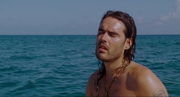 Movie still from “Forgetting Sarah Marshall” (2008), directed by Nicholas Stoller – A man with long hair is standing in the water; Close Up shot, High angle