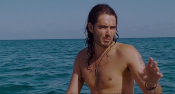 Movie still from “Forgetting Sarah Marshall” (2008), directed by Nicholas Stoller – A man with long hair is standing in the ocean; Medium shot, High angle