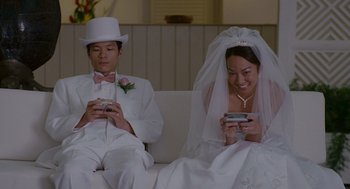 Movie still from “Forgetting Sarah Marshall” (2008), directed by Nicholas Stoller – A man and a woman sitting on a couch looking at their cell phones; Medium shot, High angle
