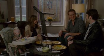 Movie still from “Forgetting Sarah Marshall” (2008), directed by Nicholas Stoller – A man and a woman sitting at a table with plates of food on it; Medium shot, Over the shoulder angle