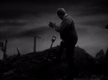 Movie still from “Frankenstein” (1931), directed by James Whale – A man standing on top of a dirt hill; Wide shot, High angle