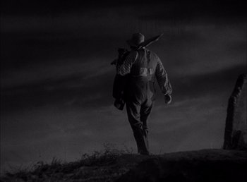 Movie still from “Frankenstein” (1931), directed by James Whale – A man walking up a hill holding a rifle; Wide shot, Low angle