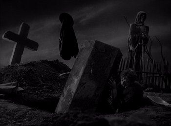 Movie still from “Frankenstein” (1931), directed by James Whale – A black - and - white photo of a child laying on the ground next to a grave; Wide shot, High angle