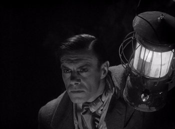 Movie still from “Frankenstein” (1931), directed by James Whale – A black and white photo of a man holding a lantern; Close Up shot, Low angle