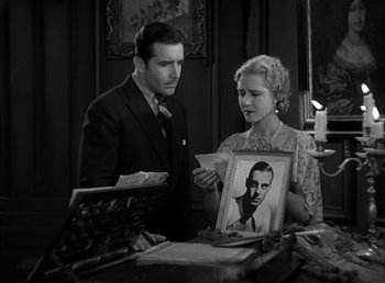 Movie still from “Frankenstein” (1931), directed by James Whale – A man and a woman looking at an old photo; Medium shot, High angle