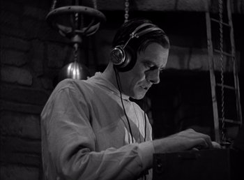 Movie still from “Frankenstein” (1931), directed by James Whale – A black and white photo of a man wearing headphones; Close Up shot, Low angle