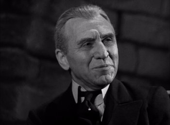 Movie still from “Frankenstein” (1931), directed by James Whale – An older man wearing a suit and tie; Close Up shot, Low angle