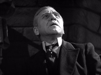 Movie still from “Frankenstein” (1931), directed by James Whale – An older man wearing a suit and a tie; Close Up shot, Low angle