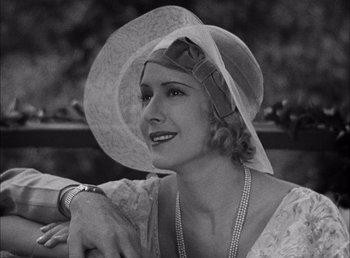 Movie still from “Frankenstein” (1931), directed by James Whale – A woman wearing a white hat and a white dress; Close Up shot, Low angle