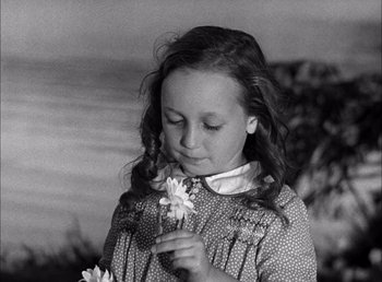 Movie still from “Frankenstein” (1931), directed by James Whale – A little girl is holding a flower in her hands; Close Up shot, High angle