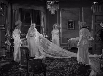 Movie still from “Frankenstein” (1931), directed by James Whale – A group of people in a room with a wedding dress on; Wide shot, High angle