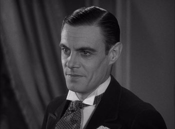 Movie still from “Frankenstein” (1931), directed by James Whale – A man in a suit and tie looking at the camera; Close Up shot, Low angle