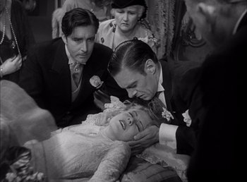 Movie still from “Frankenstein” (1931), directed by James Whale – An old black and white photo of a woman laying on a bed; Medium shot, High angle