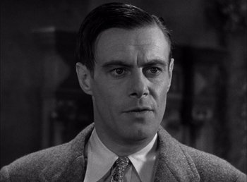 Movie still from “Frankenstein” (1931), directed by James Whale – A black and white photo of a man in a suit and tie; Close Up shot, Low angle