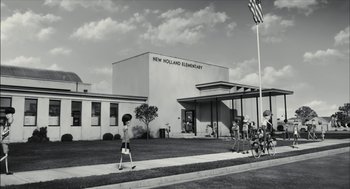 Movie still from “Frankenweenie” (2012), directed by Tim Burton – A black and white photo of a new holland elementary school; Extreme Wide shot, Low angle