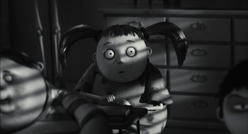 Movie still from “Frankenweenie” (2012), directed by Tim Burton – A black - and - white photo of a doll with pigtails; Medium shot, High angle