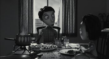 Movie still from “Frankenweenie” (2012), directed by Tim Burton – A person sitting at a table with a plate of food; Medium shot, Over the shoulder angle