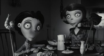 Movie still from “Frankenweenie” (2012), directed by Tim Burton – A black and white photo of two people sitting at a dinner table; Medium shot, High angle