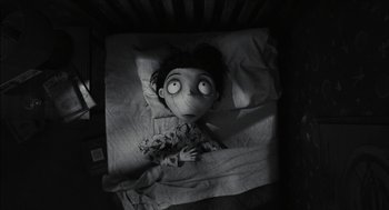Movie still from “Frankenweenie” (2012), directed by Tim Burton – A doll is laying in a bed with a blanket; Medium shot, Overhead angle