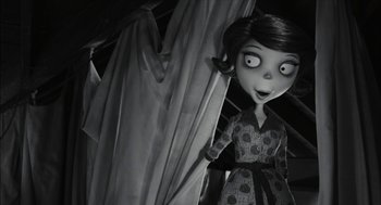 Movie still from “Frankenweenie” (2012), directed by Tim Burton – A black - and - white photo of a woman in a polka dot dress; Medium shot, Over the shoulder angle