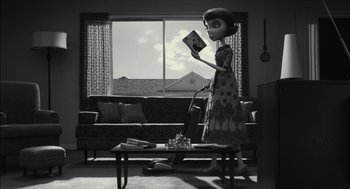 Movie still from “Frankenweenie” (2012), directed by Tim Burton – A black - and - white photo of a living room with a couch , coffee table , and window; Wide shot, High angle