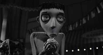 Movie still from “Frankenweenie” (2012), directed by Tim Burton – A black - and - white photo of a person eating a cupcake; Close Up shot, High angle