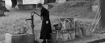 Movie still from “Frantz” (2016), directed by François Ozon – An old woman standing next to a fire hydrant; Wide shot, Low angle