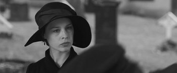Movie still from “Frantz” (2016), directed by François Ozon – A woman wearing a black hat and a black shirt; Close Up shot, Over the shoulder angle