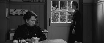 Movie still from “Frantz” (2016), directed by François Ozon – A woman sitting at a table with a cup of coffee; Medium shot, Over the shoulder angle