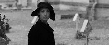 Movie still from “Frantz” (2016), directed by François Ozon – A woman wearing a hat standing next to a grave yard; Medium shot, Low angle