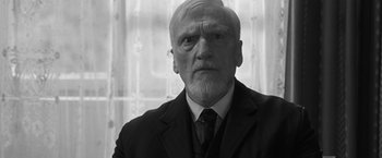 Movie still from “Frantz” (2016), directed by François Ozon – An older man in a suit and a tie; Close Up shot, Low angle