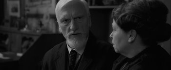Movie still from “Frantz” (2016), directed by François Ozon – An older man with a white beard is looking at a younger woman; Close Up shot, Over the shoulder angle