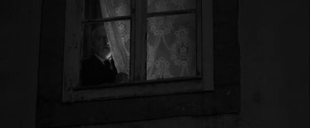 Movie still from “Frantz” (2016), directed by François Ozon – An old man looking out of a window at night; Medium shot, Low angle