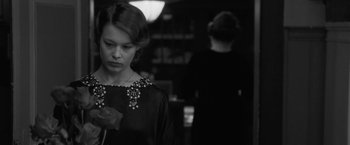 Movie still from “Frantz” (2016), directed by François Ozon – A black and white photo of a woman holding a flower; Close Up shot, Over the shoulder angle