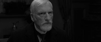 Movie still from “Frantz” (2016), directed by François Ozon – An old man with a beard and a suit and tie; Close Up shot, Over the shoulder angle