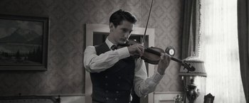 Movie still from “Frantz” (2016), directed by François Ozon – A man playing the violin in a room; Close Up shot, Low angle