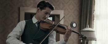 Movie still from “Frantz” (2016), directed by François Ozon – A man playing the violin in a room; Close Up shot, Low angle