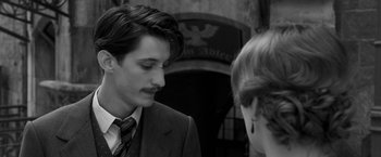 Movie still from “Frantz” (2016), directed by François Ozon – A man in a suit and tie talking to a woman in a suit; Close Up shot, Over the shoulder angle