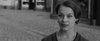 Movie still from “Frantz” (2016), directed by François Ozon – Black and white photograph of a young woman in front of a building; Close Up shot, Over the shoulder angle