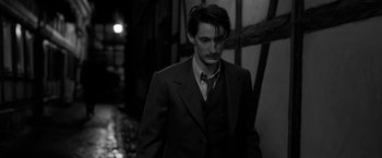 Movie still from “Frantz” (2016), directed by François Ozon – A black and white photo of a man in a suit and tie; Close Up shot, Over the shoulder angle
