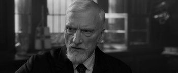 Movie still from “Frantz” (2016), directed by François Ozon – An older man with a beard and a suit and tie; Close Up shot, Over the shoulder angle