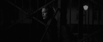 Movie still from “Frantz” (2016), directed by François Ozon – A woman standing next to a metal gate; Medium shot, Low angle